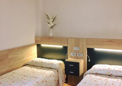 Habitación doble luminosa en Residencia Pirineos, residencia de mayores en Zaragoza con camas ergonómicas, mobiliario funcional y ambiente tranquilo.
