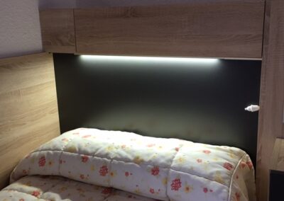 Detalle de dormitorio en Residencia Pirineos, residencia de mayores en Zaragoza con habitaciones cómodas, modernas y adaptadas al descanso de los residentes.