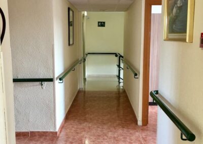 Pasillo interior accesible en Residencia Pirineos, residencia de mayores en Zaragoza con seguridad y adaptaciones para personas con movilidad reducida.